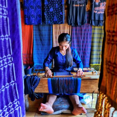 Home Indonesian woman weaving traditional cloth in Baduy village, Banten.